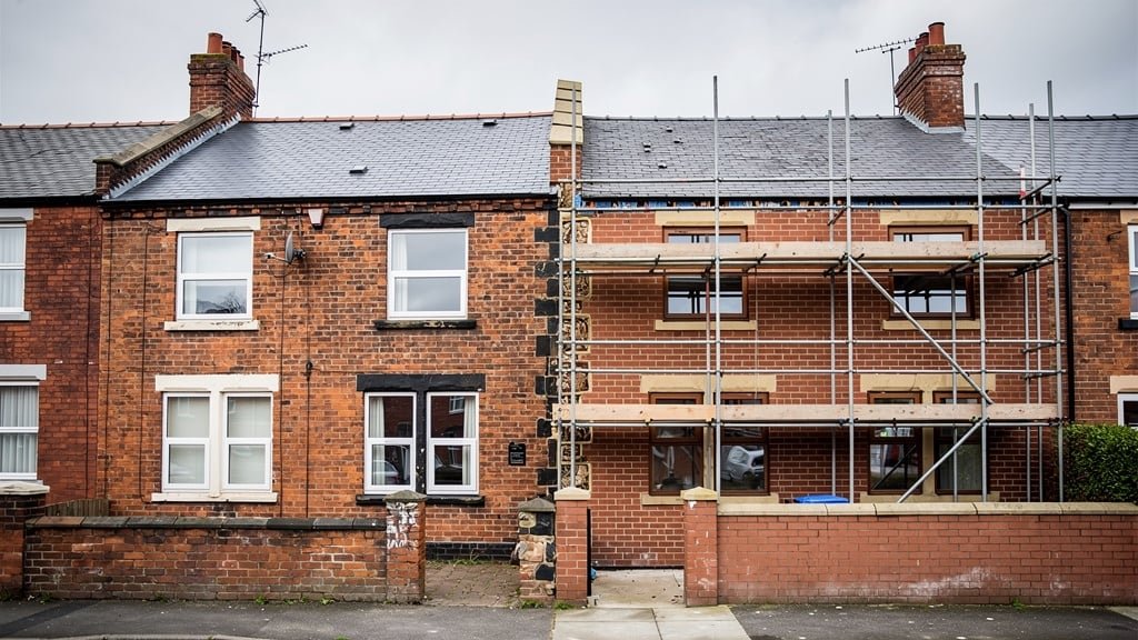 Two adjoining Bolton terraced houses sharing a party wall with a construction extension and scaffolding
